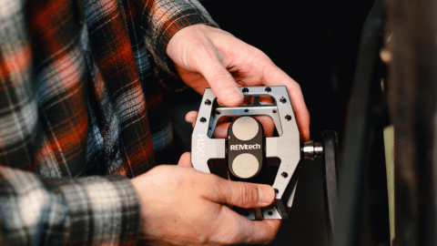 Close up of a guy installing a Gunmetal Gray Pedal on his bike.