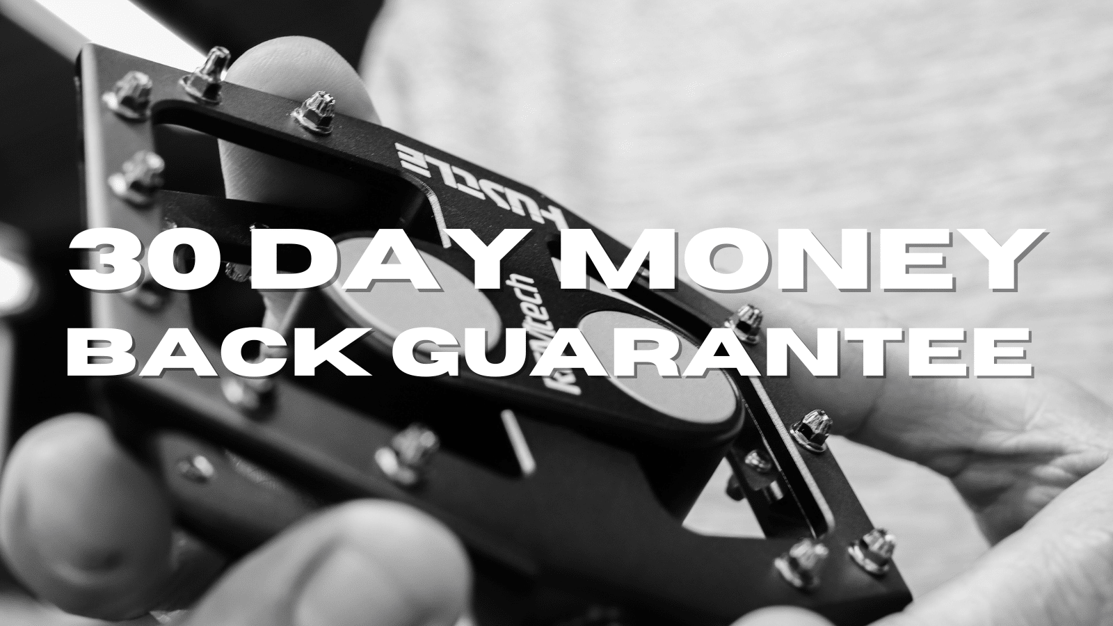 Black and white close up of Craigo holding a REMtech pedal with the wording, "30 Day Money Back Guarantee" overlaid.