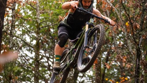 Turtle Boss flying over a drop on a Bentonville Trail with is REMtech Magnetic Pedals.