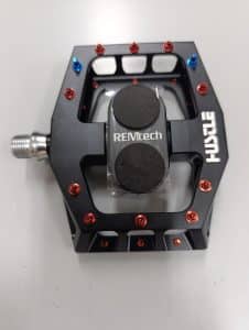 Black magnetic mtb pedal with blue and red pedal pins.